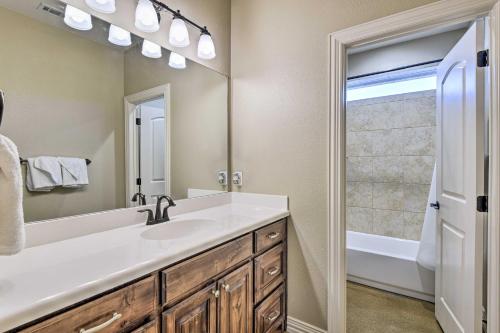 a bathroom with a sink and a mirror and a tub at Secluded Krum Home with Patio and Gas Grill! in Krum