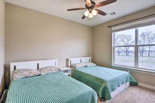 a bedroom with two beds and a ceiling fan at Secluded Krum Home with Patio and Gas Grill! in Krum