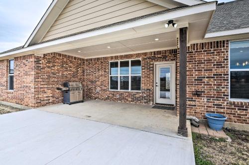 a brick house with a back patio with a trash can at Secluded Krum Home with Patio and Gas Grill! in Krum