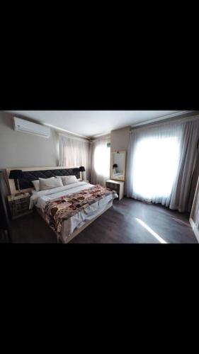 een slaapkamer met een groot bed en een raam bij Luxurious studio in the heart of Heliopolis in Caïro