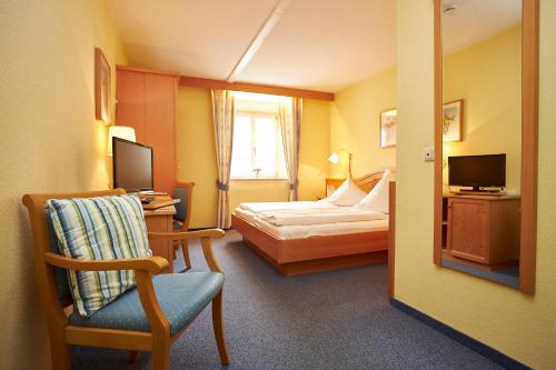 a hotel room with a bed and a chair and a mirror at Gasthof-Hotel Zur Post Samerberg in Törwang