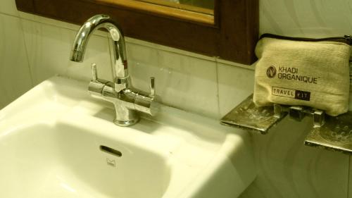 a bathroom sink with a faucet and a towel at NISARGA in Yercaud