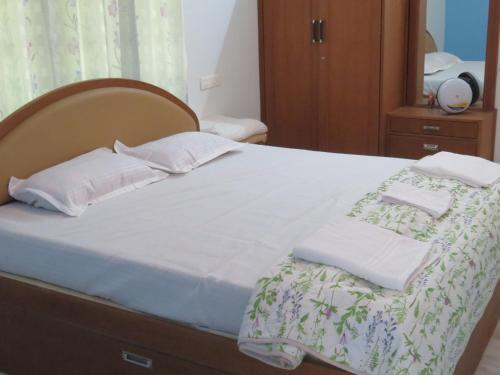 a bedroom with a bed with white sheets and pillows at NISARGA in Yercaud