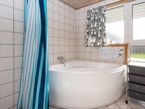 baño con bañera blanca y ventana en 8 person holiday home in Hejls, en Hejls