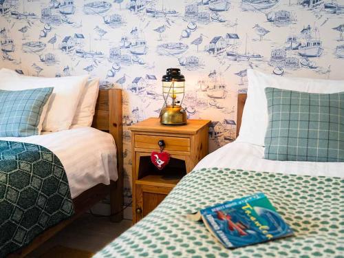 um quarto com 2 camas e um candeeiro numa mesa de cabeceira em Harbour House em Portree