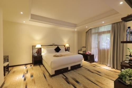een slaapkamer met een bed en een groot raam bij De Leopol Hotel in Addis Ababa