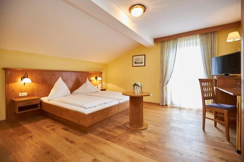 a hotel room with a bed and a television at Gasthof-Hotel Zur Post Samerberg in Törwang