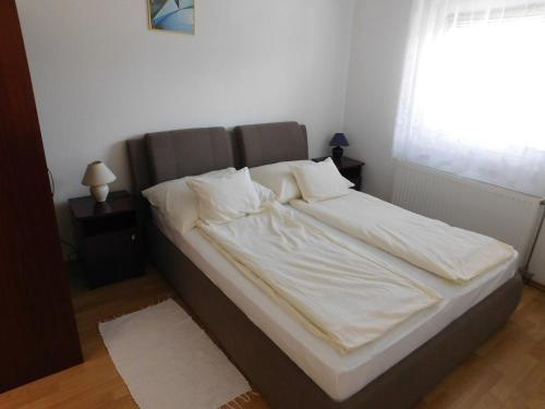 ザラカロシュにあるAkácfa Hortenzia Apartmanのベッドルーム(白いシーツと枕付)