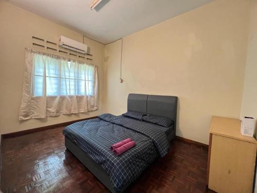 a bedroom with a bed with a pink object on it at Batu Pahat Airbnb Homestay Empire 9 in Batu Pahat