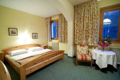 a bedroom with a bed and a table and a window at Goldener Ochs in Golling an der Salzach