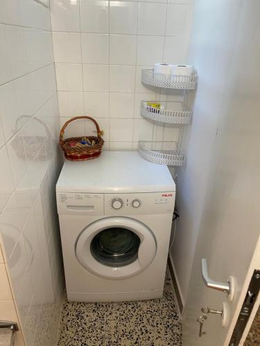 a washing machine with a basket on top of it at Cozy Flat Loutra Aidipsou in Loutra Edipsou