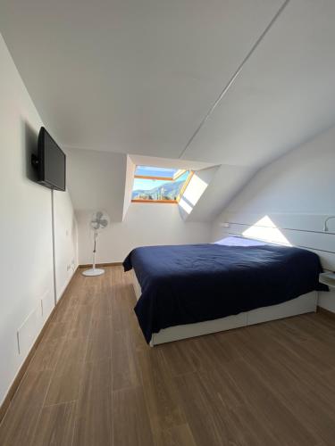 1 dormitorio con 1 cama y TV de pantalla plana en Apartamento Almogaren, en Valsequillo