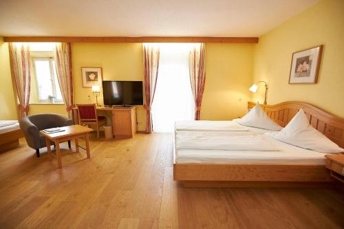 a hotel room with a bed and a desk and a television at Gasthof-Hotel Zur Post Samerberg in Törwang