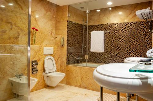 La salle de bains est pourvue d'un lavabo, de toilettes et d'une douche. dans l'établissement Taj Chandigarh, à Chandigarh