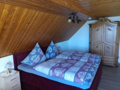 una camera con letto e soffitto in legno di Ferienhaus Schöne Aussicht a Esch