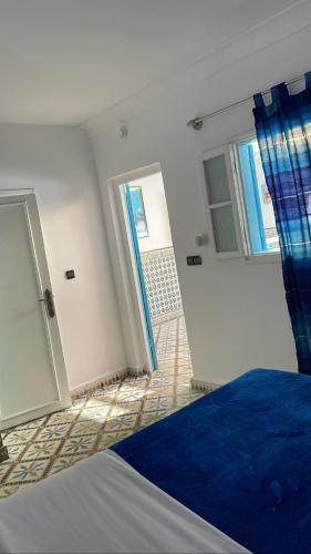 a bedroom with a bed with a blue comforter at Riad chez brahim in Essaouira