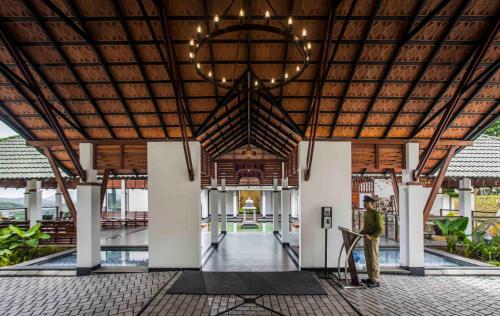 a man standing in the middle of a building at GReaT Trails Wayanad by GRT Hotels in Wayanad