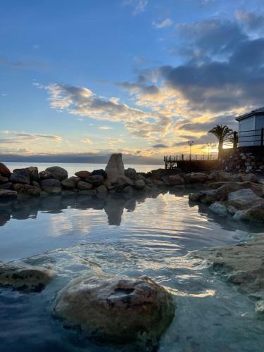 a large pool of water with rocks and the ocean at Cozy Flat Loutra Aidipsou in Loutra Edipsou