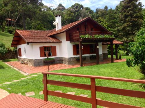 een klein huis met een hek ervoor bij Hospedagem Spa da Alma in Monte Verde