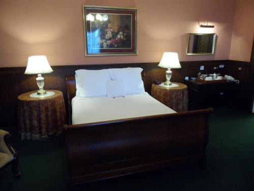 a bedroom with a bed with two lamps on two tables at Clifton Motel & Grittleton Lodge in Bunbury