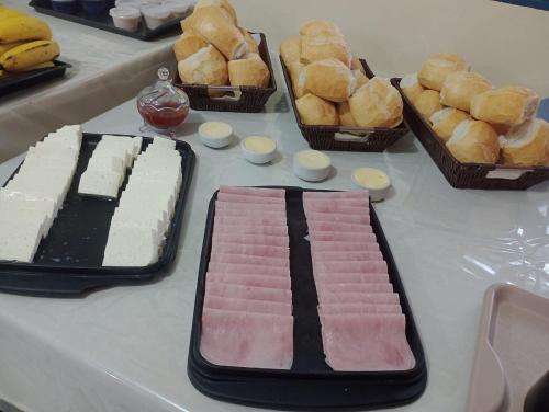 Novo Hotel Três Lagoas في تريس لاغواس: طاولة مليئة بمختلف أنواع المعجنات والخبز