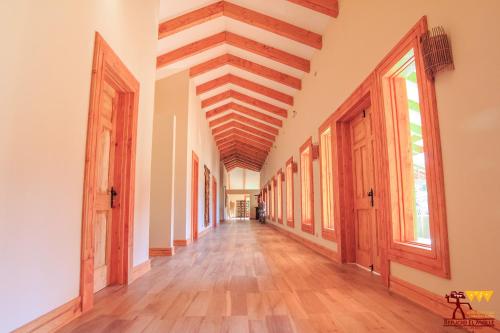 an empty hallway with a wooden ceiling and wooden floors at Hotel Boutique Refugio El Molle in El Molle