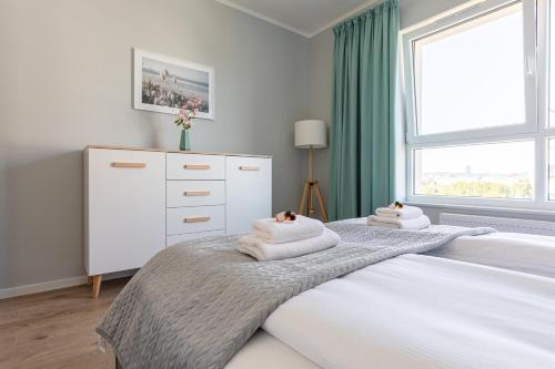 a bedroom with a bed with towels on it at Baltica Towers by Symphony Aparthotels in Gdańsk