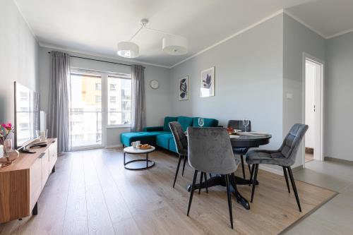 a living room with a blue couch and a table at Baltica Towers by Symphony Aparthotels in Gdańsk