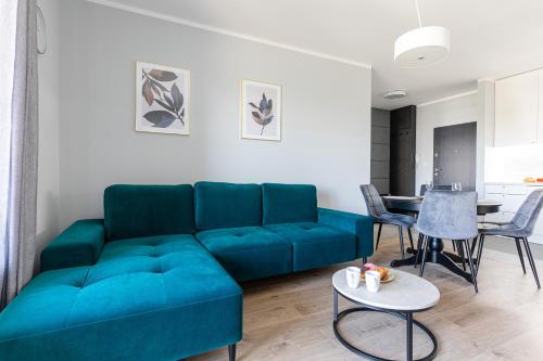 a living room with a blue couch and a table at Baltica Towers by Symphony Aparthotels in Gdańsk