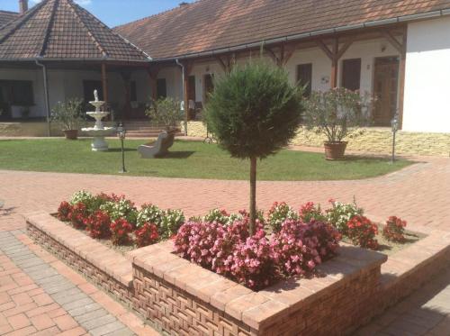 a garden with flowers and a tree in a yard at Bornemisza Kúria Wellness Resort in Tiszabecs