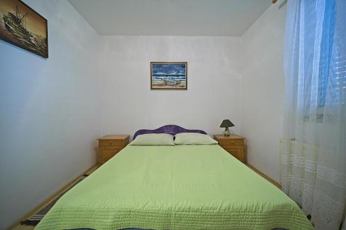 a bedroom with a bed with a green blanket at Apartment Renata in Postira