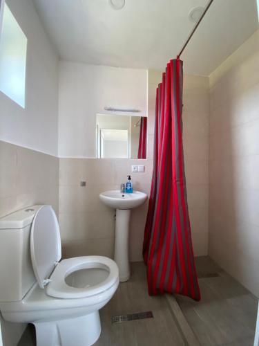 łazienka z czerwoną zasłoną prysznicową i toaletą w obiekcie Дом на пляже Black sea House w Kobuleti