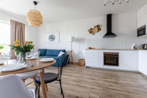 a kitchen and living room with a table and a dining room at Baltica Towers by Symphony Aparthotels in Gdańsk