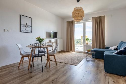 a living room with a table and a blue couch at Baltica Towers by Symphony Aparthotels in Gdańsk
