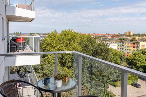 a balcony with a table and a view of a city at Baltica Towers by Symphony Aparthotels in Gdańsk