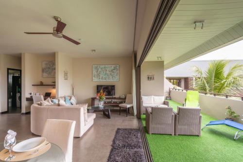 a living room with white furniture and green grass at SLEEP IN MAURITIUS in Grand Baie