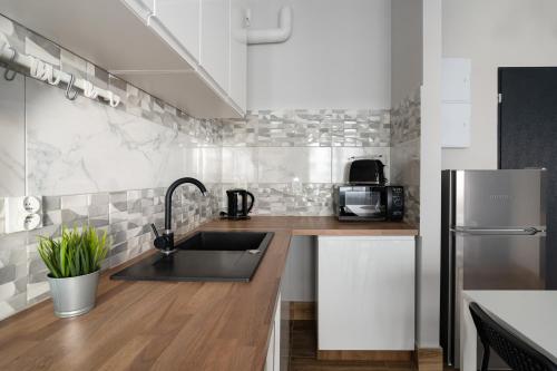 a kitchen with a sink and a refrigerator at Baltica Towers by Symphony Aparthotels in Gdańsk