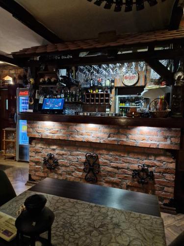 a bar with a brick wall and a bar table at Etno kuca sa konacistem GOCKO in Vrnjačka Banja