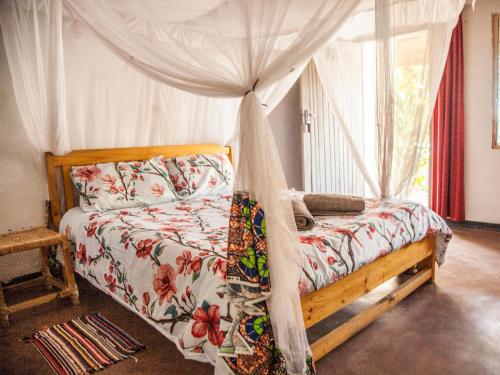 ein Schlafzimmer mit einem Himmelbett in der Unterkunft Thumbi View Lodge in Cape Maclear