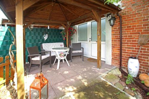 a patio with a table and chairs under a pavilion at Romantik Landhaus & Pension Klaps Liebling in Lübben