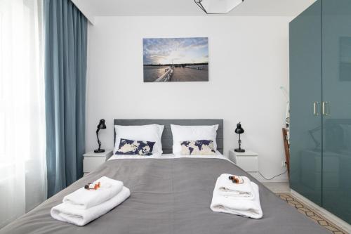 a bedroom with a bed with towels on it at Baltica Towers by Symphony Aparthotels in Gdańsk