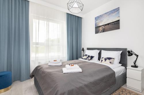 a bedroom with a large bed with two towels on it at Baltica Towers by Symphony Aparthotels in Gdańsk