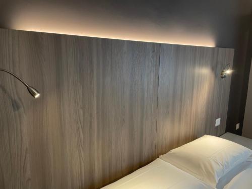 a bed in a room with a wooden wall at Hotel Lukas Vegetarian & Vegan in Viareggio