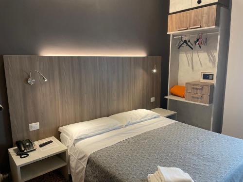 a small bedroom with a bed and two tables at Hotel Lukas Vegetarian & Vegan in Viareggio