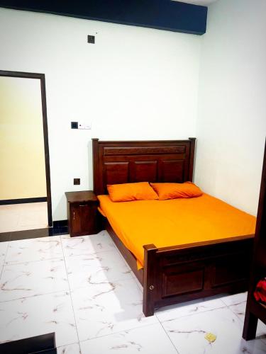 una camera da letto con un letto con lenzuola arancioni e uno specchio di Hotel sun cafe 