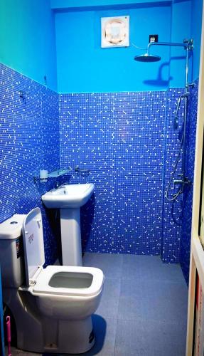 La salle de bains bleue est pourvue de toilettes et d'un lavabo. dans l'établissement Hotel sun cafe, 