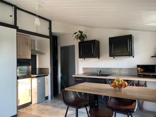 - une cuisine avec une table, des chaises et un évier dans l'établissement Chez Dominique et Bruno à 20 mm du PuyduFou, à Bazoges-en-Paillers