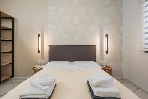 a bedroom with a large white bed with towels on it at Orama Luxury Apartments in Nea Kydonia
