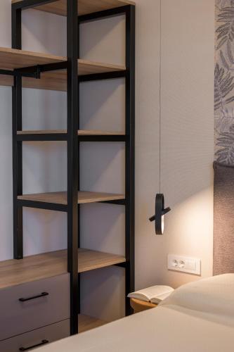 a bedroom with a book shelf next to a bed at Orama Luxury Apartments in Nea Kydonia