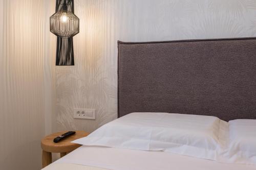 a bedroom with a bed with a headboard and a lamp at Orama Luxury Apartments in Nea Kydonia